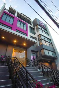 un edificio rosa y blanco con escaleras delante en OYO 1030 Ai Hotel, en Manila