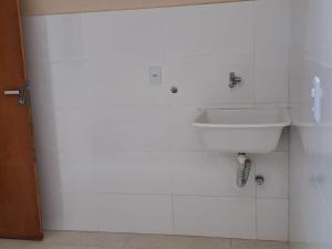 uma casa de banho com um lavatório e uma parede branca em Casa de praia em Mucuri Bahia em Mucuri