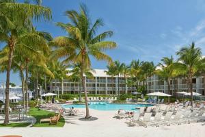 un complejo con piscina, sillas y palmeras en Hilton Fort Lauderdale Marina, en Fort Lauderdale