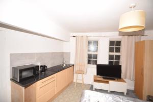a kitchen with a sink and a microwave in a room at Lordship Studios in London