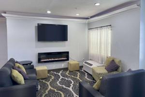 a living room with two couches and a flat screen tv at La Quinta by Wyndham Tulare in Tulare
