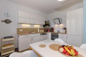 a kitchen with a bowl of fruit and vegetables on a table at Haus Emilia Whg Baltic Dreams in Rerik