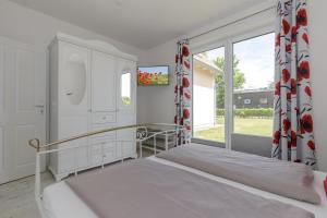 a bedroom with a bed and a large window at Haus Emilia Whg Baltic Dreams in Rerik
