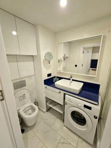 a bathroom with a toilet and a sink and a washing machine at Orbi City Sea View in Batumi +11 photos