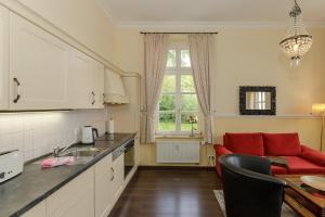 een keuken en een woonkamer met een rode bank bij Gutsschloss Rerik, "Belle Etage" in Rerik