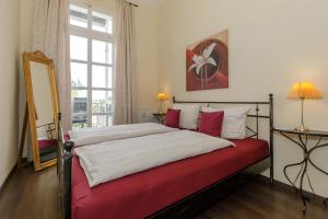een slaapkamer met een rood-wit bed en een spiegel bij Gutsschloss Rerik, "Belle Etage" in Rerik