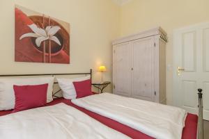 een slaapkamer met een groot bed met rode en witte kussens bij Gutsschloss Rerik, "Belle Etage" in Rerik