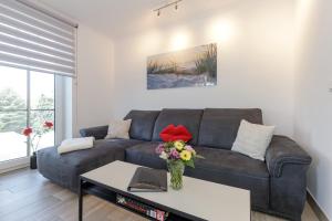 sala de estar con sofá y mesa con flores en StrandEins Whg_ 6 _Baltica_ en Rerik