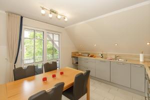 a kitchen with a wooden table and a dining room at Strandvilla Luv Lee Kapitaen-Suite in Rerik