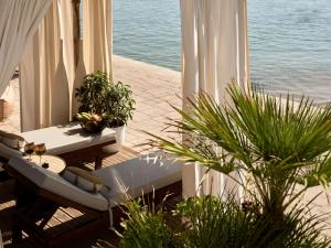 einen Balkon mit einem Tisch, Pflanzen und Wasser in der Unterkunft The Royal Senses Resort & Spa Crete, Curio Collection by Hilton in Panormos