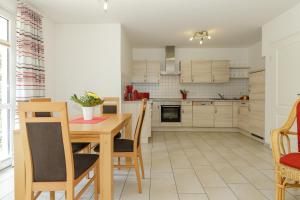 a kitchen with a wooden table and a dining room at Villa Antonia Whg_ 4 in Rerik