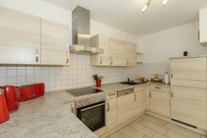 a kitchen with wooden cabinets and a stove top oven at Villa Antonia Whg_ 4 in Rerik