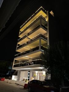 a tall building with a car parked in front of it at ICON Urban Living Trikala in Tríkala