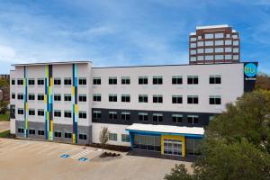 a white building with a tall building in the background at Tru By Hilton North Richland Hills DFW West in North Richland Hills