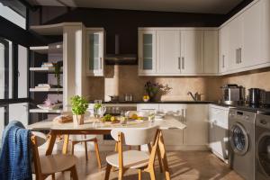 a kitchen with white cabinets and a table and chairs at 22 Eikehoff Apartment in Stellenbosch +2 photos