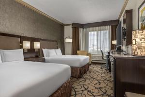 内蒂克The Verve Boston Natick, Tapestry Collection by Hilton的有两张床和一张书桌的酒店房间 更多37张照片