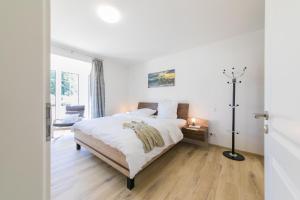 a white bedroom with a large bed and a desk at "La Belle Vie" in Neu Gaarz
