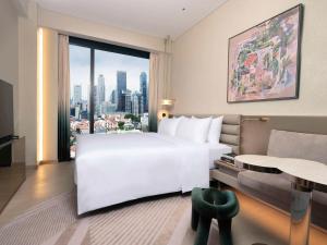 a bedroom with a large white bed and a large window at Mondrian Singapore Duxton in Singapore