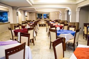 un restaurante con mesas y sillas con manteles azules y rojos en Medos Hotel, en Kusadasi