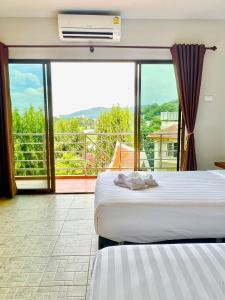 a hotel room with two beds and a balcony at My Friend's House Karon in Karon Beach +83 photos