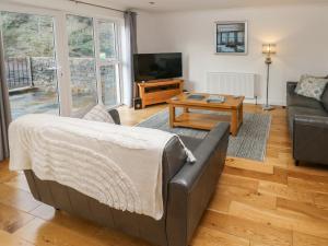 una sala de estar con un sofá y una mesa en Curlew, en Milford Haven