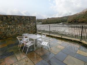 a table and chairs on a patio with a fence at Curlew in Milford Haven