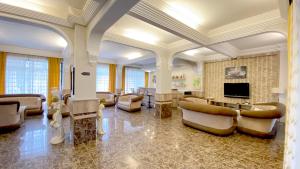 ein großes Wohnzimmer mit Sofas und einem TV in der Unterkunft Medos Hotel in Kusadası