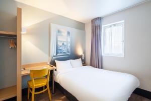 a hotel room with a bed and a desk at B&B HOTEL Maurepas in Maurepas