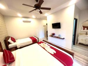 1 dormitorio con 2 camas y ventilador de techo en Luangprabang Villa bouathong Hotel en Luang Prabang