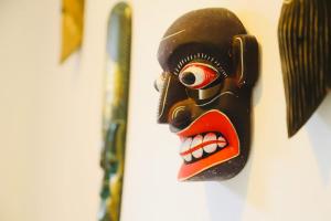 a wooden mask hanging on a wall at kandy hill vilaa in Kandy