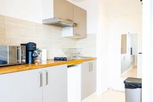 a kitchen with white cabinets and a microwave at ZenBNB / Azur / Proche Tram / Studio / Balcon Privé in Annemasse
