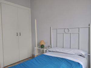 1 dormitorio con cama blanca y manta azul en Paneras del Rey, en Ávila