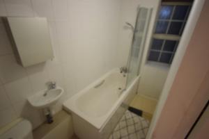 a bathroom with a sink and a tub and a toilet at Lordship Studios in London