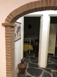 Una habitación con un arco de piedra y un dormitorio en Quintinha dos Pombinhos en Montoito