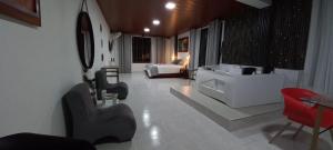 uma ampla sala de estar com uma banheira e uma cama em Hotel la casona de Wiky em Guaduas