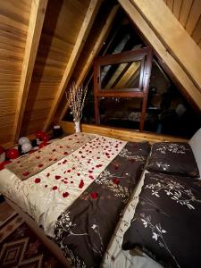 a bed with flowers on it in a attic at Vila Šibovi in Banja Luka