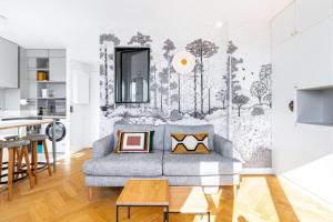 ein Wohnzimmer mit einem Sofa und einer Küche in der Unterkunft Élégant Studio cosy avec vue Tour Eiffel in Boulogne-Billancourt