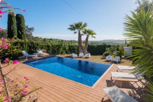 einen Pool auf einer Holzterrasse mit Stühlen und Bäumen in der Unterkunft CC-1 Casa de Campo 8Pax in Begur