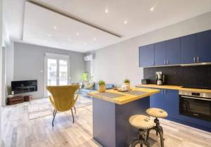 a kitchen with blue cabinets and a yellow chair at Charming 1 bedroom apartment near the center in Athens