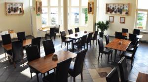 un comedor con mesas, sillas y ventanas en Hotel TIREST, en Grebiszew