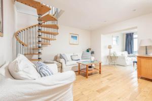 a living room with white furniture and a spiral staircase at Sea View - Stunning views from patio - Sleeps 4 in Pittenweem