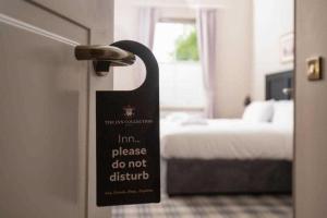 a sign on the door of a room with a bed at The Ullswater Inn- The Inn Collection Group in Glenridding