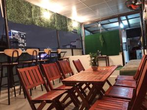 a dining room with a table and chairs and a green screen at Saigon Cozy Hotel in Ho Chi Minh City