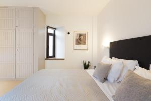 a bedroom with a large bed with white sheets and a window at Antigoni's Seaside Lodge, a beach retreat! in Rethymno Town