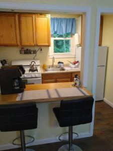 a kitchen with a counter and two bar stools at Quaint Cabin By The Creek Private in Pipestem