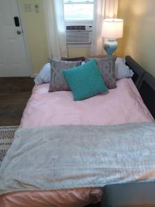 1 dormitorio con 1 cama con almohada verde en Quaint Cabin By The Creek Private, en Pipestem