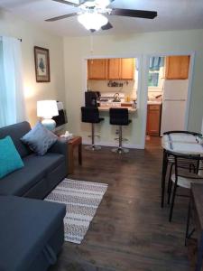 a living room with a couch and a kitchen at Quaint Cabin By The Creek Private in Pipestem