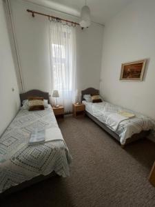 two beds in a bedroom with two lamps and a window at Apartment Croatia in Zagreb
