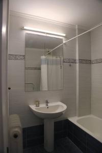 Charming apartment near center في أثينا: حمام مع حوض ومرآة وحوض استحمام