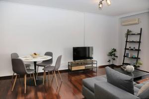 Charming apartment near center في أثينا: غرفة معيشة مع أريكة وطاولة وتلفزيون